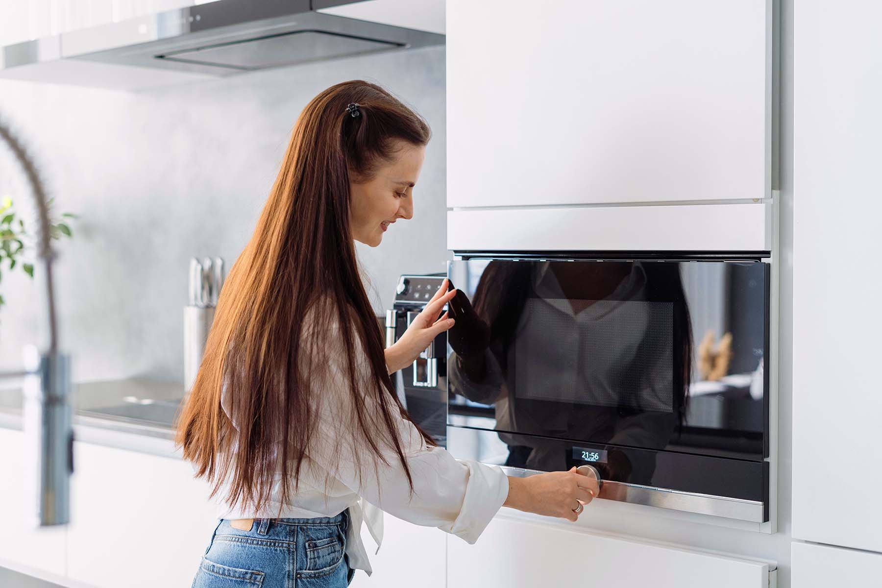 woman entering time on a built in microwave