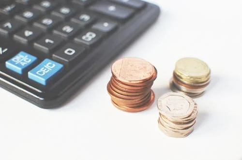 Coins next to a calculator 