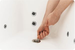 A hand unclogging a drain.