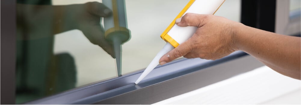 Person fixing drafty window