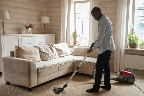 man vacuuming carpet