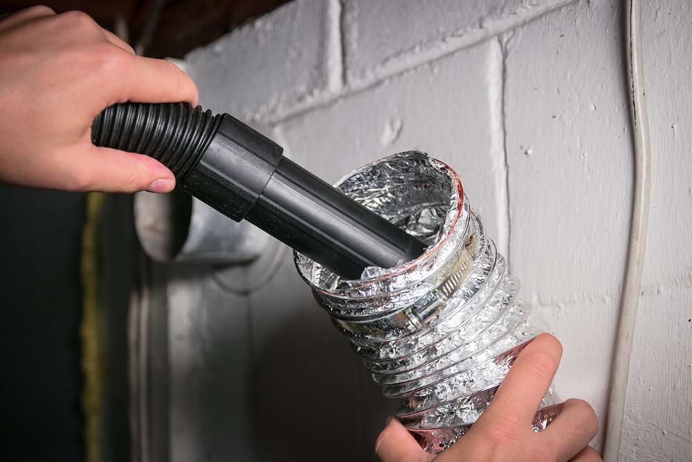 Person using vacuum to clean dryer vent